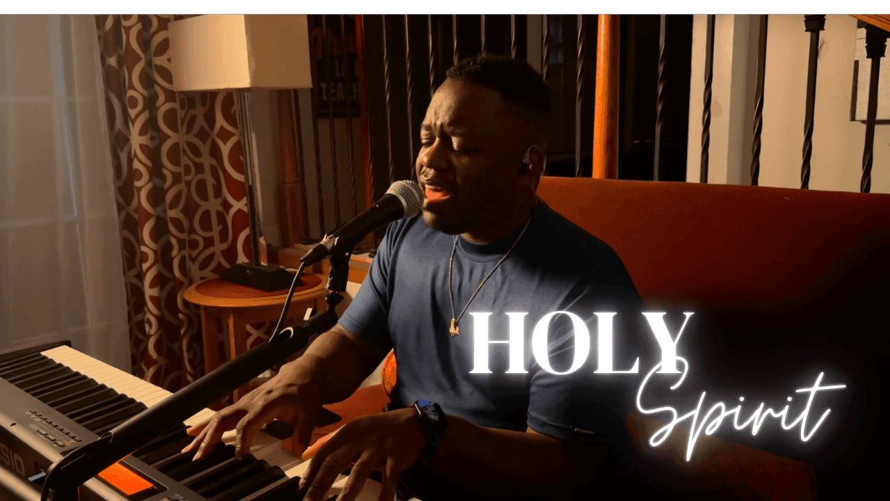 Man singing passionately into a microphone while playing keyboard, text 'Holy Spirit' glowing beside him.